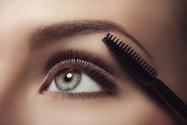 Woman Brushing Long Eyelashes from Serum