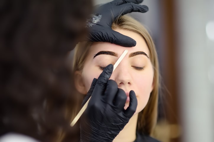 Woman Getting Eyebrows Tinted and Waxed