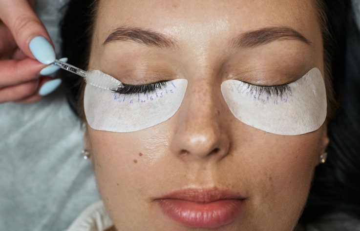 Woman Getting Eyelash Extensions Brushed 