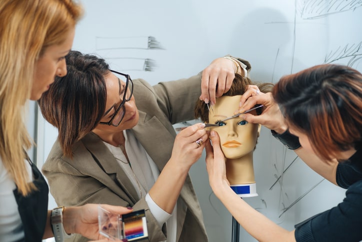 Women learning how to apply eyelash extensions