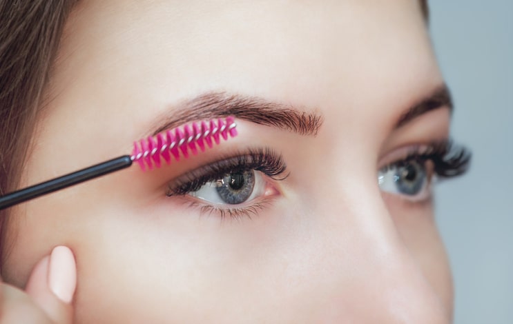 Woman Brushing Eyelash Extensions